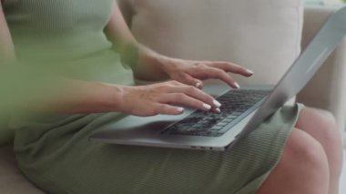 Evde kanepede oturan kablosuz bilgisayarla çalışan meşgul kadın yöneticiyi yavaş yavaş yukarı kaldır.