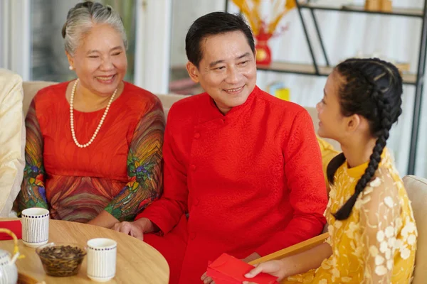 Vietnamese family gathered together to have tea with treats and celebrate Lunar New Year