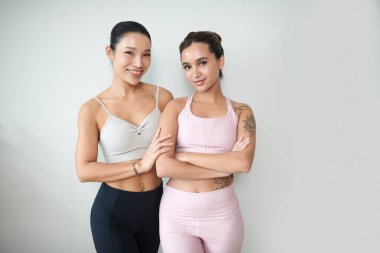 Spor kıyafetleri giyen neşeli bayan arkadaşların portresi.