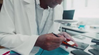 Servis dükkanında bozuk cep telefonunu tamir ederken çoklu metre kullanan Hintli tamircinin orta boy fotoğrafı.