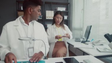 Beyaz önlüklü birkaç erkek ve kadın tamir merkezi uzmanının orta boy fotoğrafları.