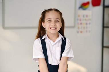 Sınıftaki mutlu, heyecanlı kız öğrencinin portresi.