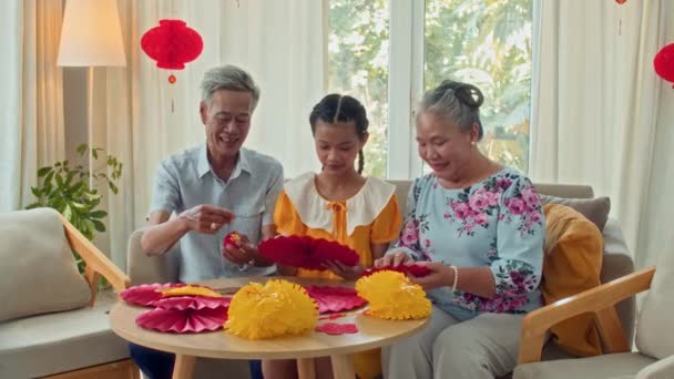 テトのお祝いのための装飾と自宅のテーブルに座っているアジアの祖父母と孫の中長い肖像画 — ストック動画