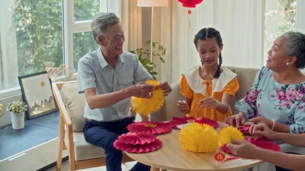 月の新年のテーブルに赤と黄色の装飾を作る多世代家族の陽気なメンバーのパンショット — ストック動画