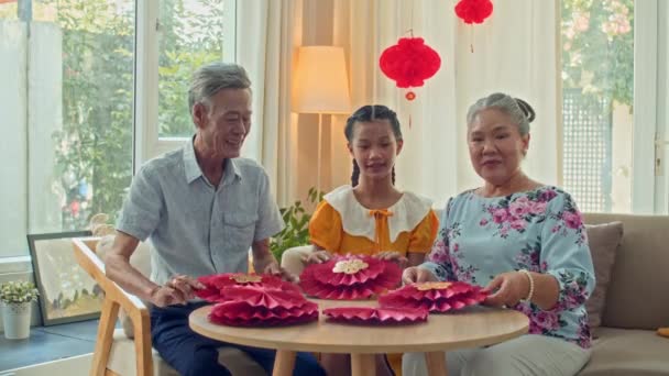 Средний Снимок Веселых Пожилых Людей Внучки Сидящих Круглым Столом Показывающих — стоковое видео