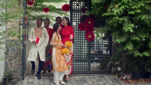 屋外でテトを祝う赤と黄色の伝統衣装の大きなベトナムの家族のワイドショット — ストック動画