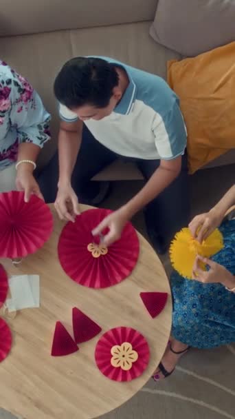亚洲家庭在家里举行的圆桌庆祝活动中垂直地制作脚手架装饰 — 图库视频影像