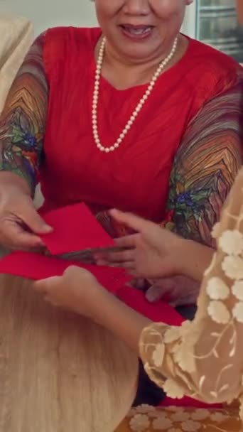 Vertikal Ausgeschnittene Aufnahme Eines Mädchens Das Rote Umschläge Als Geschenke — Stockvideo