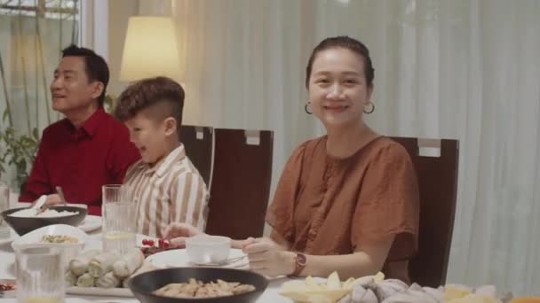 Retrato Alegre Mujer Asiática Sonriendo Cámara Mientras Está Sentada Mesa — Vídeos de Stock