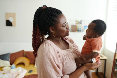 Mutlu anne küçük bebeğine bakıyor.