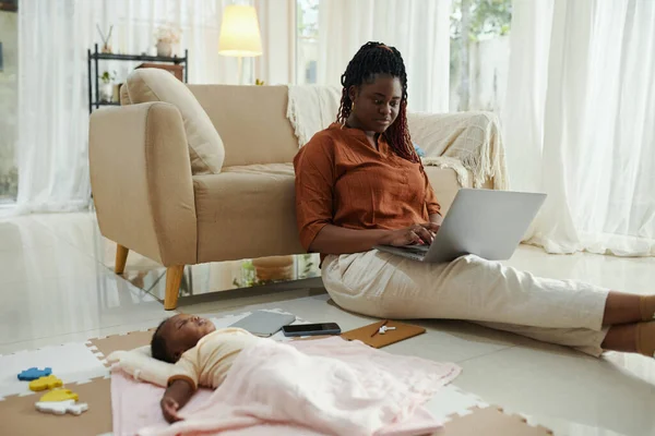 Mujer Negra Sentada Suelo Trabajando Portátil Cuando Hija Recién Nacida — Foto de Stock