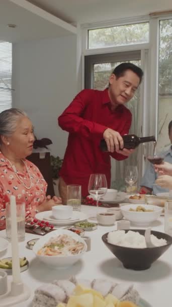 Vertikální Záběr Asijského Muže Nalévání Červené Víno Brýlích Během Party — Stock video
