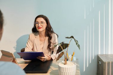 Gülümseyen zarif adam iş başvurusunda bulunan kişiye yeteneklerini ve deneyimlerini soruyor.