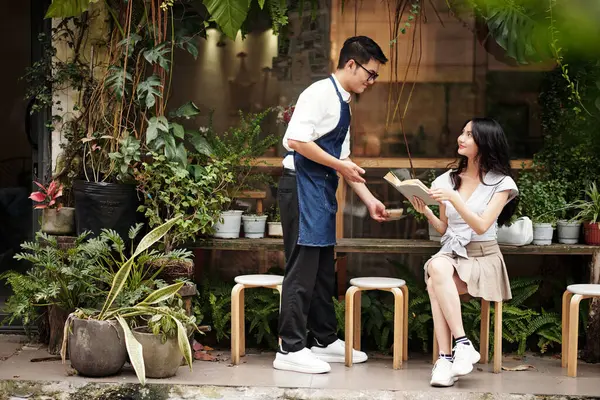 Uśmiechnięta Młoda Azjatka Flirtuje Kelnerką Przynosząc Kawę — Zdjęcie stockowe