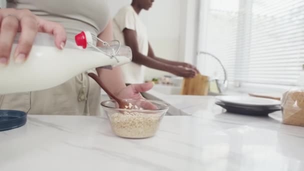 Colpo Ritagliato Ragazza Versando Latte Ciotola Con Cereali Mentre Colazione — Video Stock