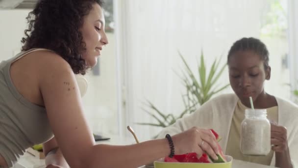 Medium Shot Van Biracial Vrouwelijke Huisgenoten Eten Watermeloen Chatten Tijdens — Stockvideo
