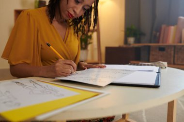 Yaratıcı Siyah moda tasarımcısı yeni koleksiyon için çizimler yapıyor