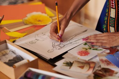 Moda tasarımcısının müşteri için çizimler çizerken yakın plan resmi