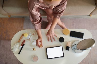 Ev elbiseli genç bir kadın, oje sürüyor. Manzaralı.