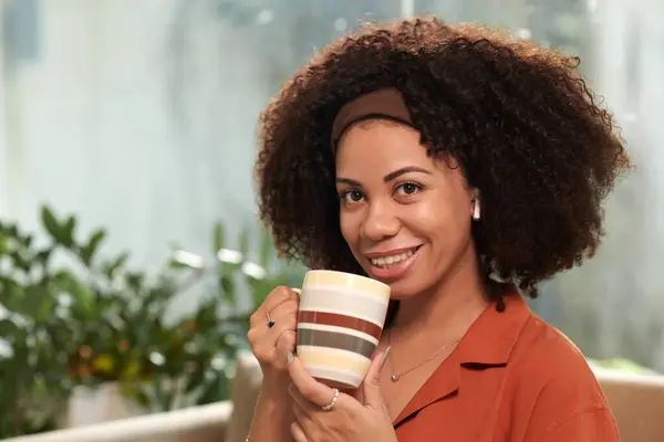 Portrait of smiling Latin woman with cup of coffee