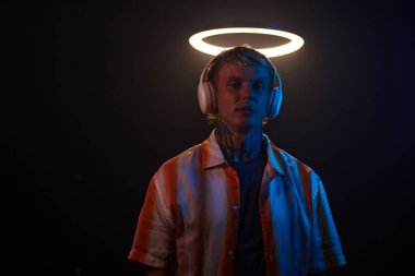 Karanlık odada, halka ışığının altında duran meloman portresi