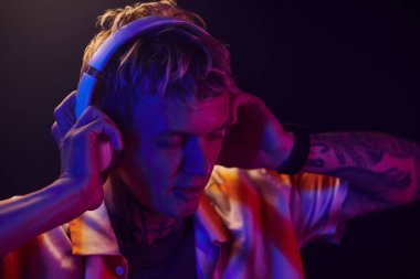 Genç adam tek başına dans ederken kulaklıkla müzik dinlemekten hoşlanıyor.