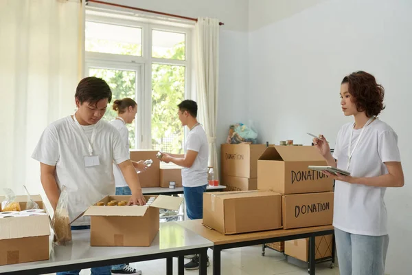 Voluntários Verificando Caixas Com Produtos Doados — Fotografia de Stock