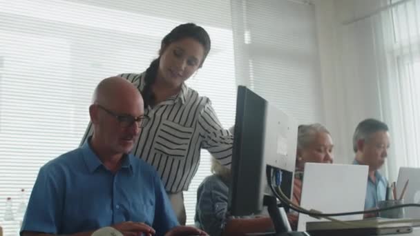 Genç Bayan Öğretmenin Grup Kursunda Erkek Emeklilere Bilgisayar Bilgisi Verirken — Stok video