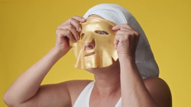 Kopflastaufnahme Einer Frau Mittleren Alters Haartuch Mit Einer Goldenen Gesichtsmaske — Stockvideo