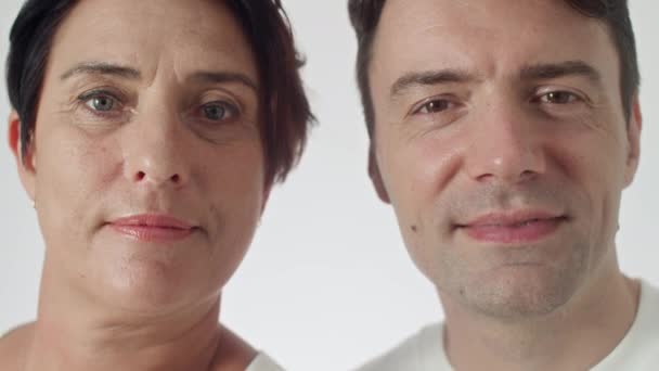 镜头近距离拍摄的中年男人和女人 蓝眼睛和褐色眼睛对着相机微笑 — 图库视频影像