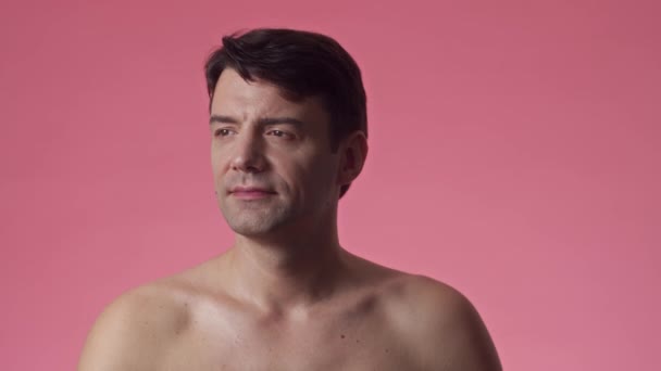 ピンクの背景に隔離されたカメラのための陽気な男性ミレニアルポーズのミディアム肖像画 — ストック動画