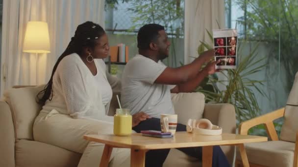 Medium Lang Afroamerikanske Ektefeller Som Diskuterer Ultralydbilde Ufødt Baby Hjemme – stockvideo