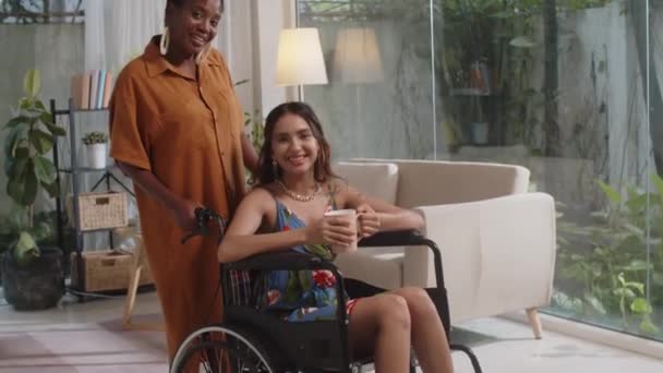 Наклоните Портрет Положительной Черной Женщины Стоящей Рядом Подругой Инвалидном Кресле — стоковое видео