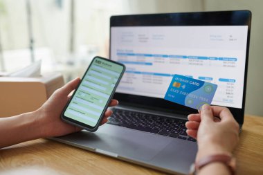 Faturaları internet üzerinden öderken kredi kartından bilgi girişi yapan kadın