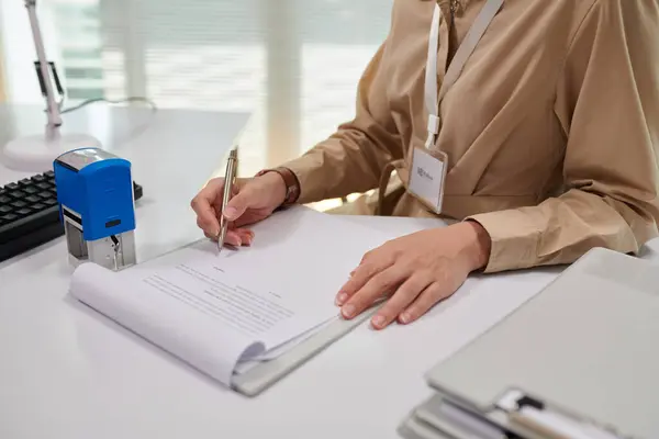 Cropped image of bank manager signing document, approving loan for client