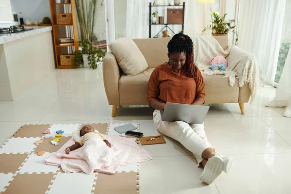 Mujer Negra Sentada Suelo Casa Trabajando Portátil Cuando Bebé Duerme —  Fotos de Stock
