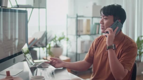 Vista Lateral Del Desarrollador Asiático Hablando Con Cliente Teléfono Inteligente — Vídeo de stock