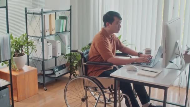 长时间坐在轮椅上沉思的员工坐在笔记本电脑前 在计算机上开发代码 — 图库视频影像