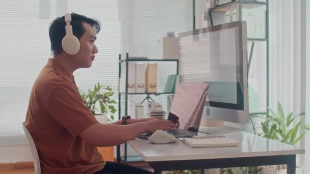 Seitenporträt Des Fröhlichen Asiatischen Programmierers Kopfhörern Der Software App Auf — Stockvideo