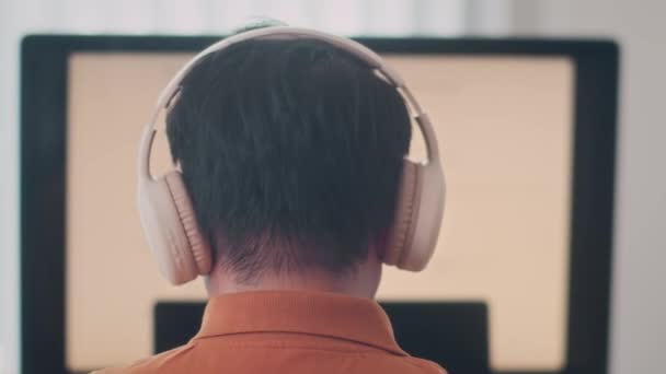 Πίσω Όψη Του Αρσενικού Κωδικοποιητή Φορώντας Ακουστικά Κάθεται Μπροστά Από — Αρχείο Βίντεο
