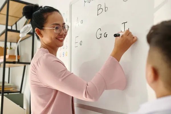 Smiling Teacher Writing Letters Whiteboard Asking Pupils Name Them — Stock Photo, Image