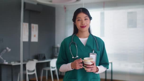 Retrato Medio Una Trabajadora Médica Uniforme Sosteniendo Una Taza Mirando — Vídeos de Stock
