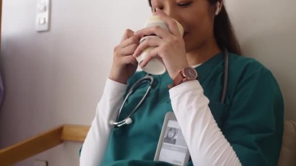 Incline Tiro Médico Asiático Fêmea Bebendo Chá Ouvir Música Fones — Vídeo de Stock