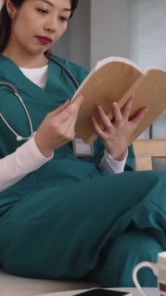 Verticaal Schot Van Aziatische Verpleegster Medisch Uniform Leesboek Tijdens Pauze — Stockvideo