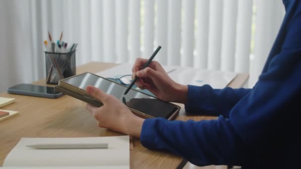 商人用数字平板电脑和钢笔在办公桌前书写会面计划的剪影 — 图库视频影像