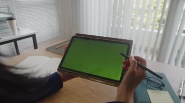 Ofiste yeşil renkli ekranlı kalem ve tablet bilgisayar kullanan iş kadınının ellerini kapat