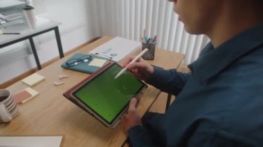 Ofis masasında çalışırken, erkek grafik tasarımcısının yeşil renkli ekran ile çiziminin kırpılmış görüntüsü