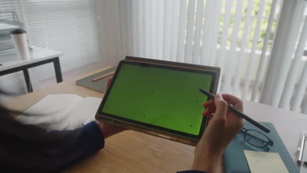 オフィスの緑色のクロマのキー スクリーンが付いているペンおよびタブレット コンピュータを使用してビジネスマンの手を閉めて下さい — ストック動画