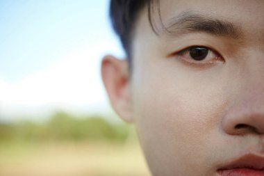 Genç Asyalı tekvando atletinin yarı yüzü dışarıda duruyor.