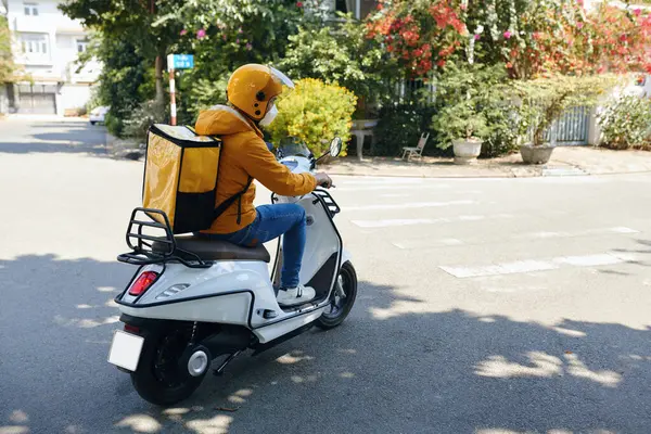 Sarı Üniformalı Teslimatçı Motosiklet Sürüyor — Stok fotoğraf